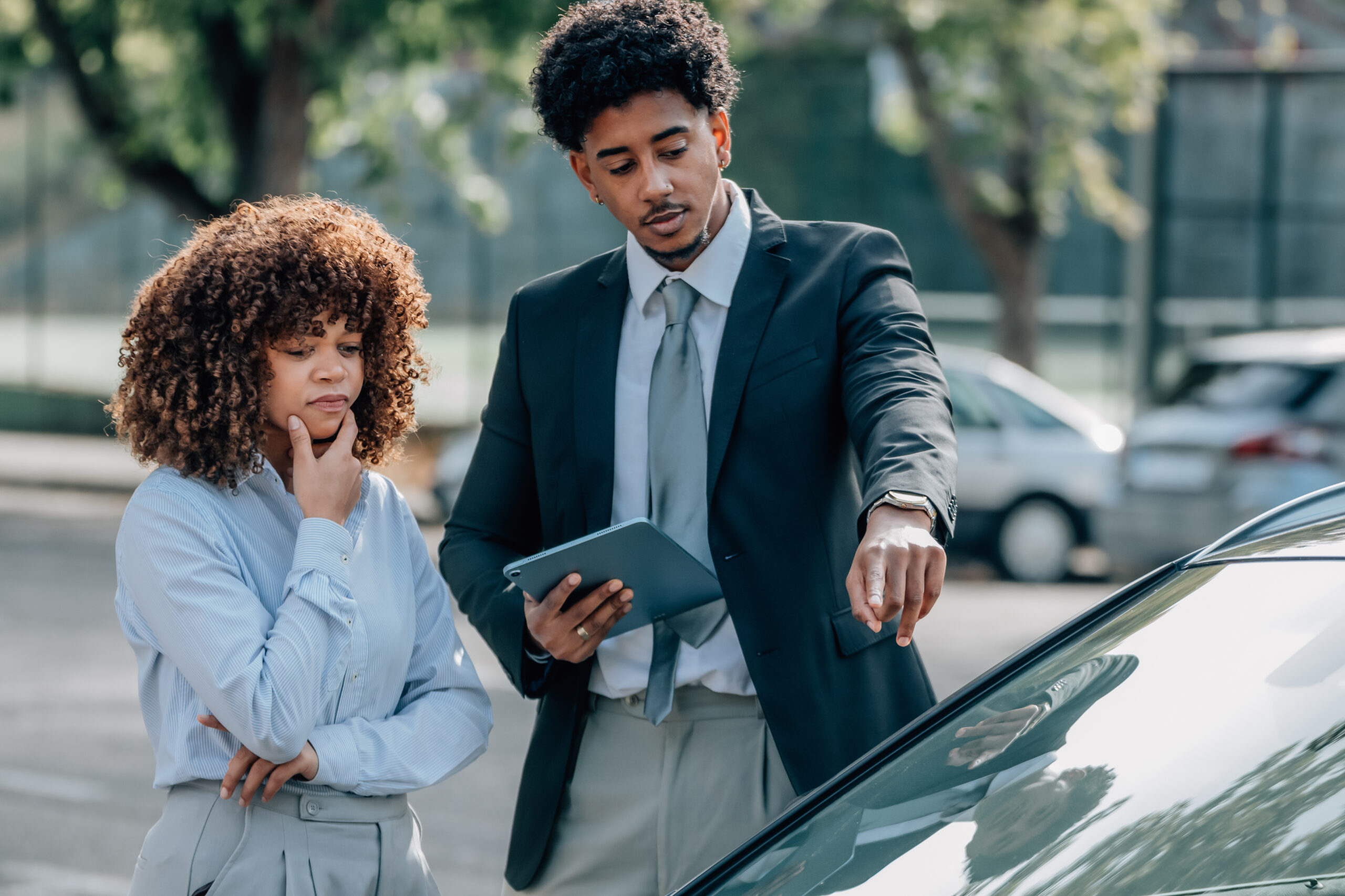 Conductrice vérifiant les garanties de son assurance auto sur smartphone dans son véhicule